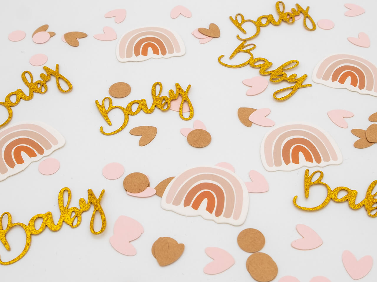 Tafelconfetti met gouden Baby-teksten, regenbogen en roze en bruine hartjes en rondjes